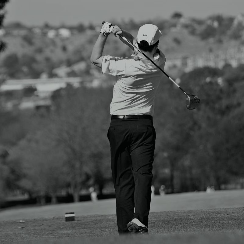 A golfer at the finish of a full swing, monochrome